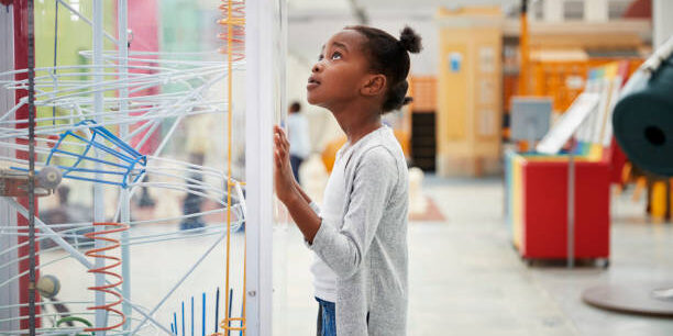 Young black girl looking at a science exhibit, close up
