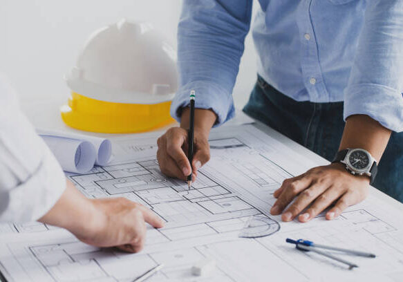 engineer meeting for an architectural project. working with partner and engineering tools working on blueprint architectural project at the construction site at desk in the office.