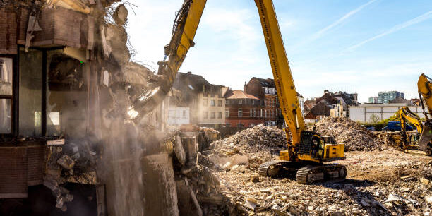 Demolition of a building in progress with a huge machine. Hydraulic Crusher excavator machine at demolition on construction site