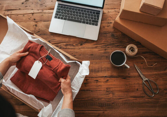 Women, owener of small business packing product in boxes, preparing it for delivery